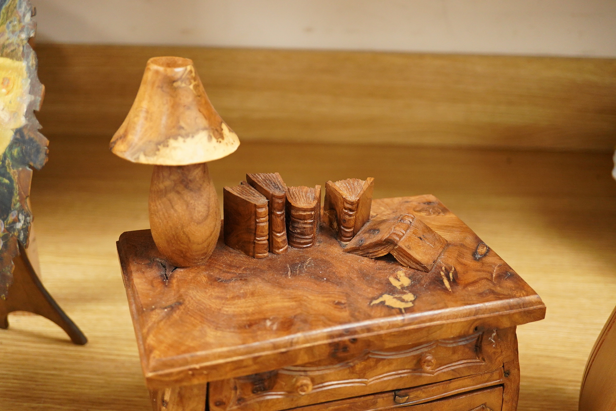 Two Piere Decorse (b.1953), a naturalistically modelled sculpture of a miniature carved novelty bureau and a sideboard, both surmounted with books and a lamp, largest 39cm high